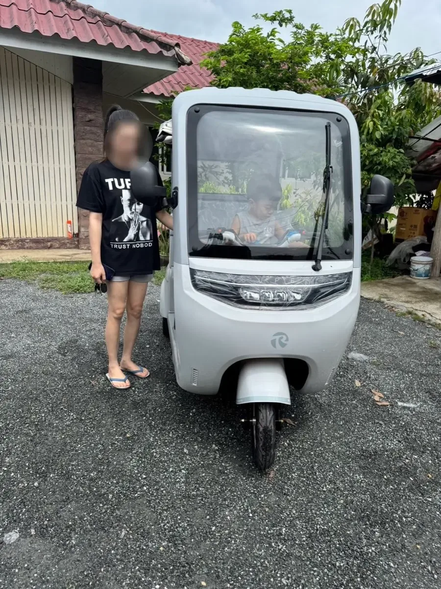 รถสามล้อไฟฟ้าสีขาวมุมด้านหน้า พร้อมเจ้าของ