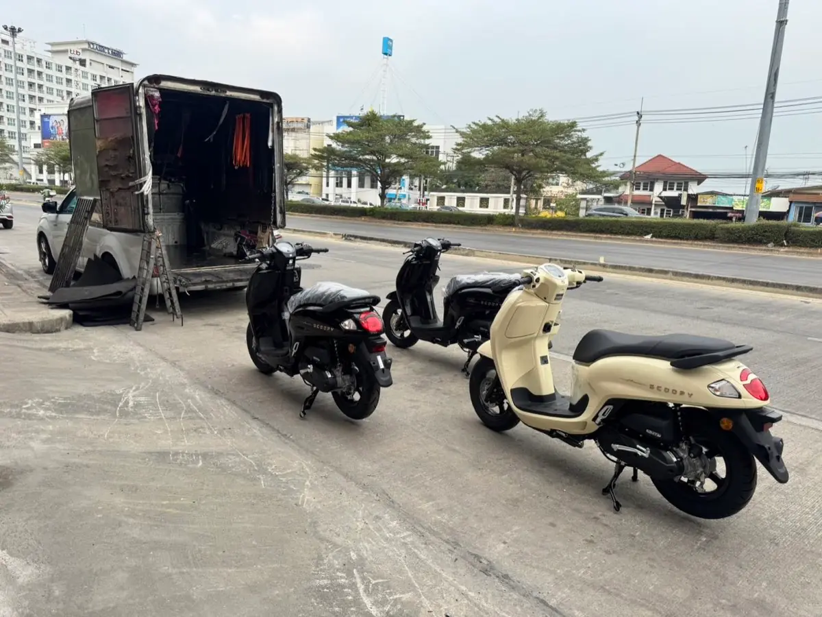 Black and cream scooters beside the box truck