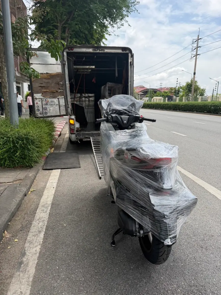 สกู๊ตเตอร์ห่อฟิล์มหน้าทางลาดขึ้นกระบะตู้