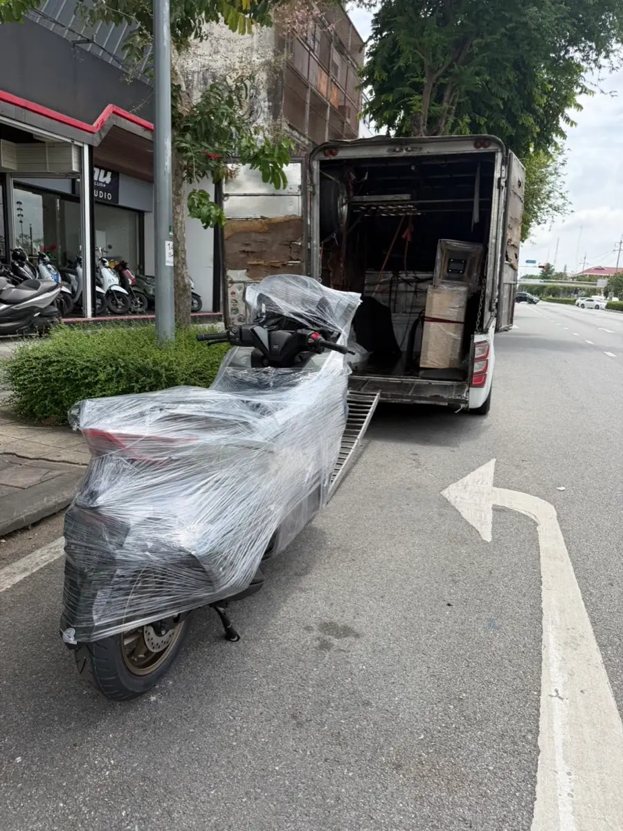 สกู๊ตเตอร์ห่อฟิล์มข้างกระบะตู้ริมถนน